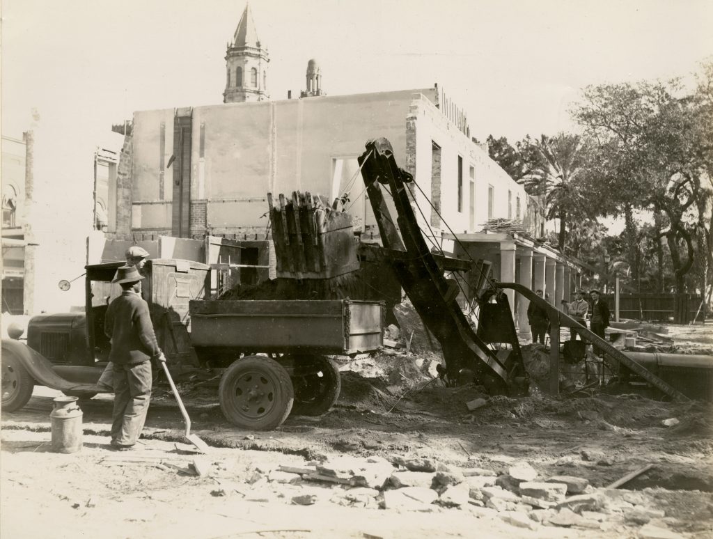 Workers using construction tools and machinery near at post office historic site