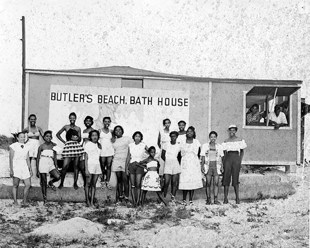 A group of young teens standing in front of a beach house at Butler Beach