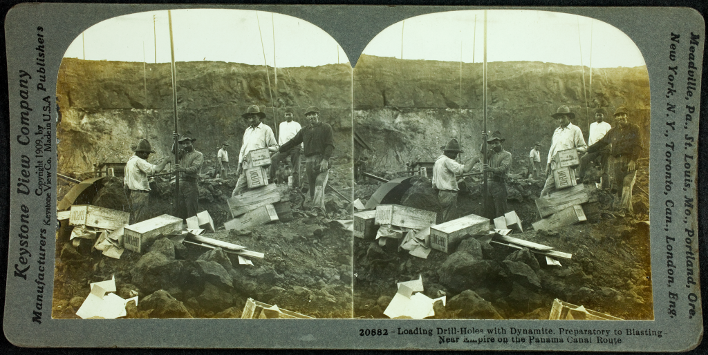 A stereograph showing workers loading drill holes with dynamite