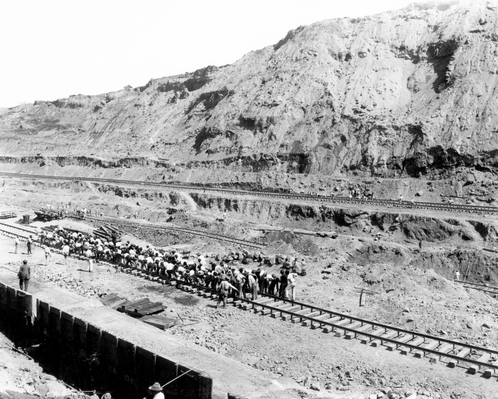 A large group of workers shifting track by hand